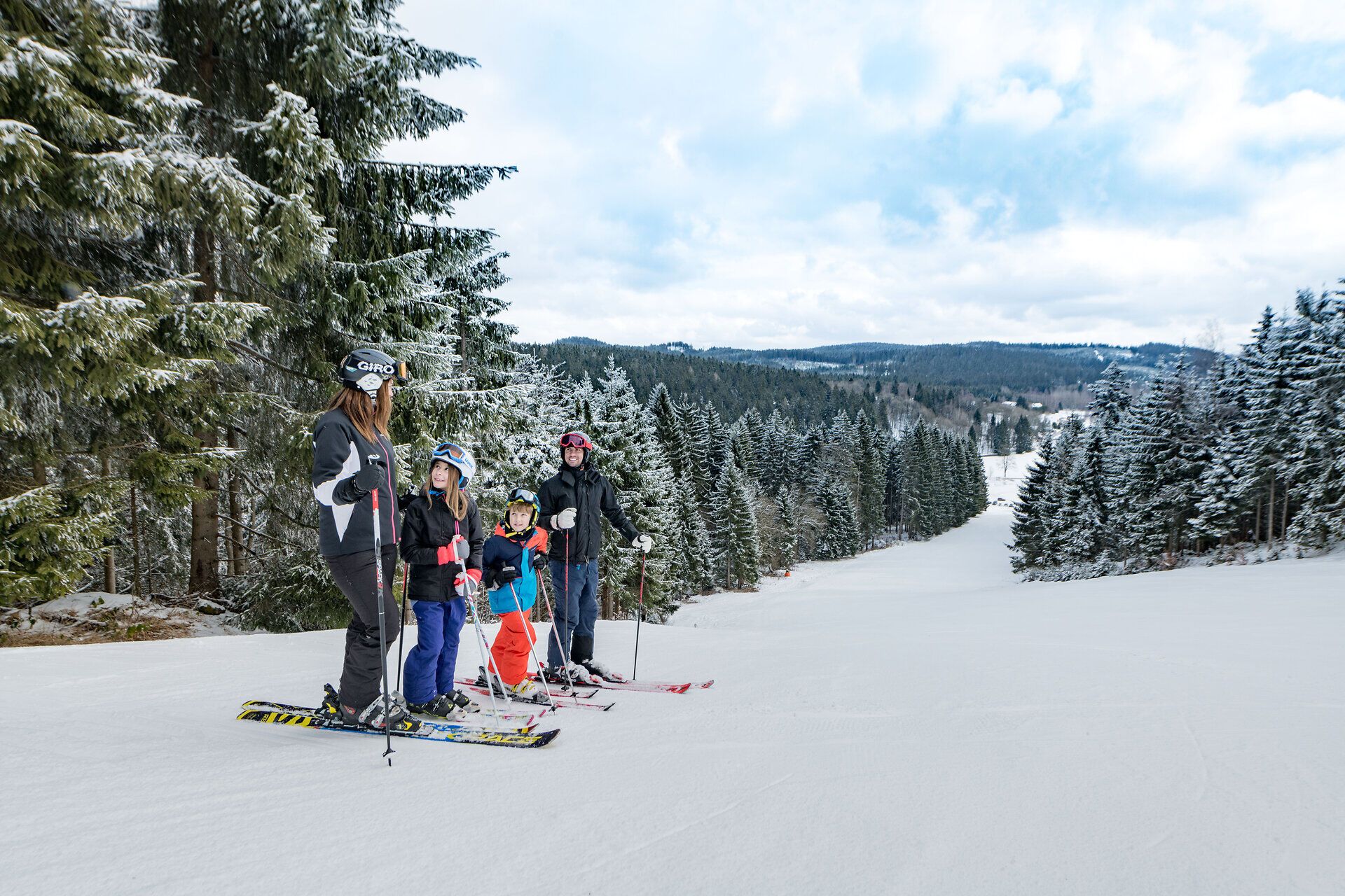 Eine Familie genießt den Winterzauber beim Skifahren in der malerischen Landschaft. Die schneebedeckten Bäume und die klare, frische Luft schaffen eine perfekte Kulisse für unvergessliche Erlebnisse auf der Piste. Hier wird der Winter zum Abenteuer für Groß und Klein.