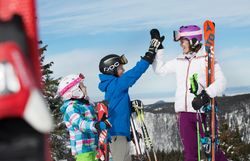 In der winterlichen Berglandschaft von Annaberg genießen Kinder und Erwachsene gemeinsam die Freude am Skifahren. Die strahlende Sonne und der glitzernde Schnee schaffen eine unvergessliche Atmosphäre für Abenteuerferien im Mostviertel.