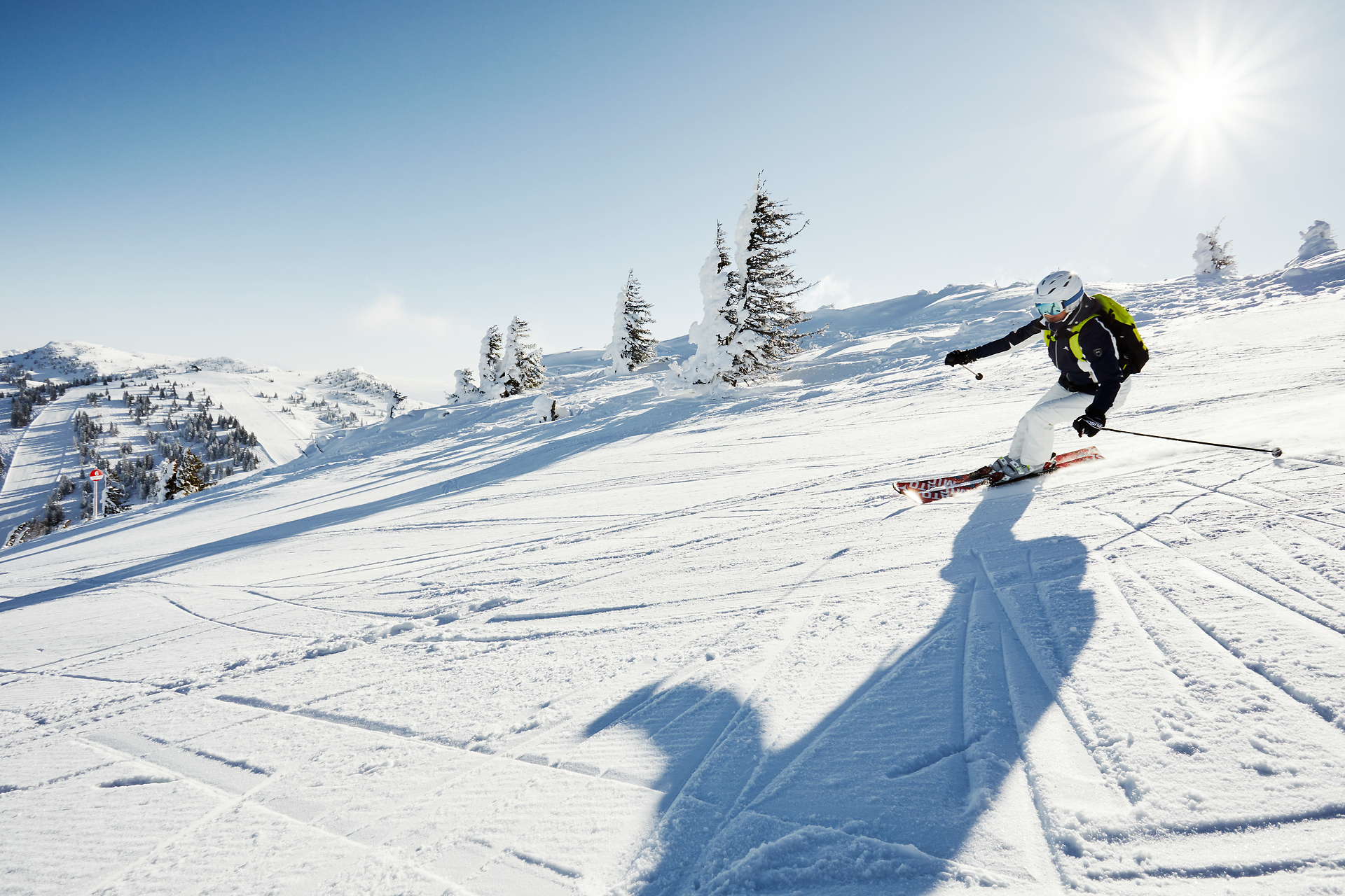 Die strahlende Sonne über dem schneebedeckten Hochkar verleiht der winterlichen Landschaft eine magische Atmosphäre. Skifahrer gleiten elegant über die glitzernde Piste, während die majestätischen Berge im Hintergrund eine beeindruckende Kulisse bieten. Hier wird der Winter zum unvergesslichen Erlebnis für alle, die die Freiheit der Berge genießen möchten.