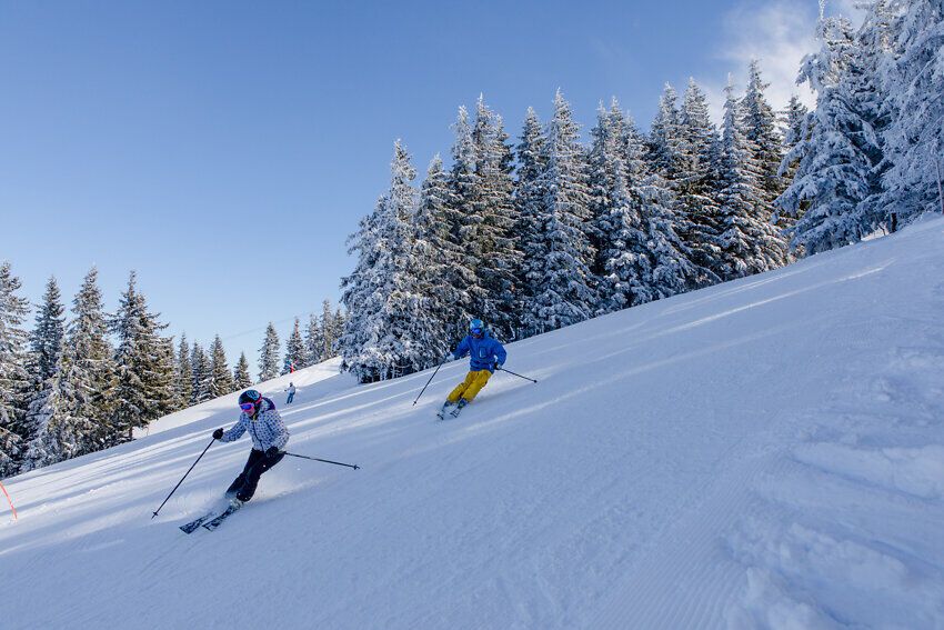 Die glitzernde Schneedecke lädt zu unvergesslichen Abfahrten ein, während die frische Bergluft die Sinne belebt. Skifahrer gleiten elegant die Pisten hinunter, umgeben von majestätischen, schneebedeckten Tannen, die eine traumhafte Winterlandschaft schaffen.