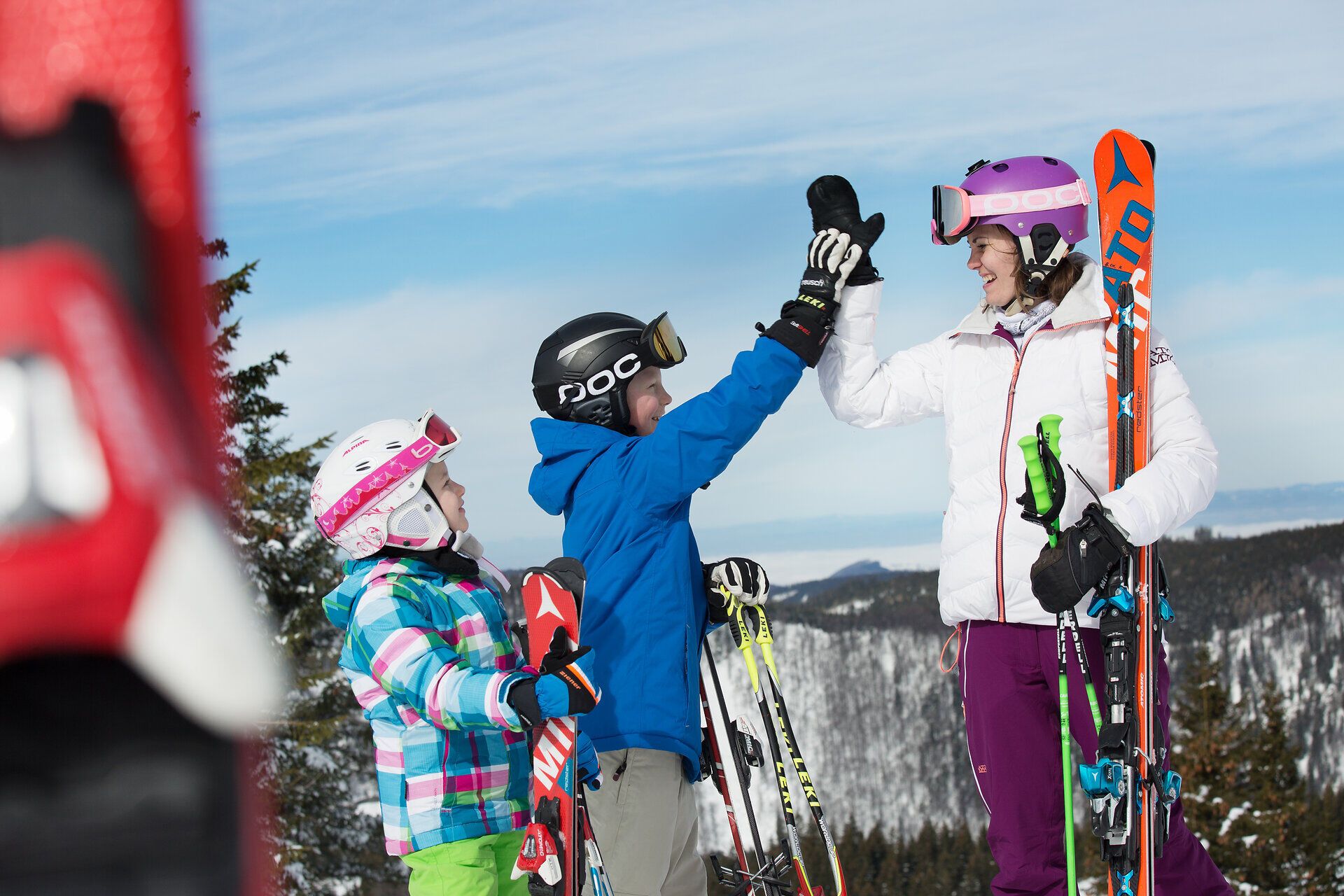In der winterlichen Berglandschaft von Annaberg genießen Kinder und Erwachsene gemeinsam die Freude am Skifahren. Die strahlende Sonne und der glitzernde Schnee schaffen eine unvergessliche Atmosphäre für Abenteuerferien im Mostviertel.